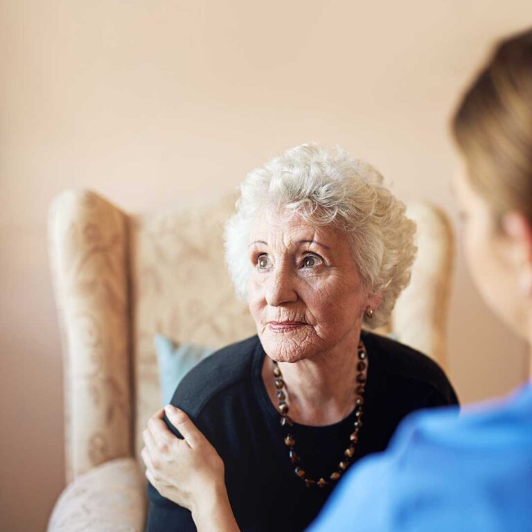 Older adults participate in a gentle group exercise session with seated stretches and light movement.